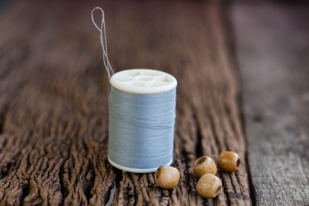 Spools of thread with needles on wooden backgroundの写真素材