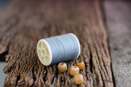 Spools of thread with needles on wooden backgroundの写真素材