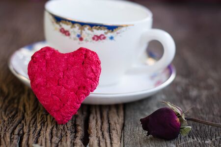 Wooden red heart and coffee cup on white wooden texture close-upの写真素材