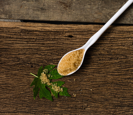 plastic spoons with sugar on oldwood backgroundの写真素材