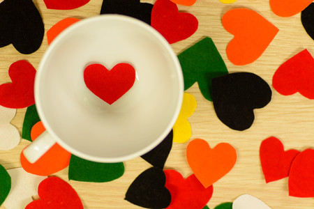 coffee cup and red heart on wooden tableの写真素材