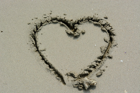 Heart drawn in the sand. Beach background. Top viewの写真素材
