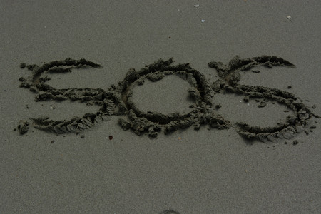 SOS - Inscription on the sand of tropical beach
