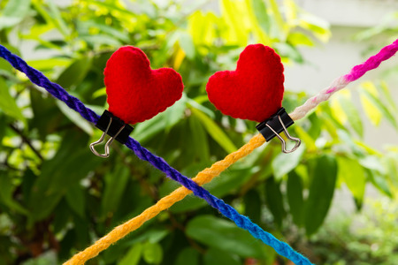 Connected group concept as many different ropes tied and linked together as an unbreakable chain as a community trust and faith metaphor. And red hearts above manyの写真素材