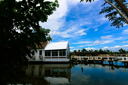 The house is on a lake with a beautiful sky in the backgroundの写真素材