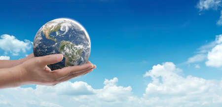 World in hand on blue sky show Earth Day, Ecology, Global warning, Environment, Save world, Love earth idea concept.の写真素材