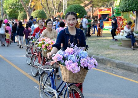 Bangkok, Thailand - January 17, 2015 Unidentified  Thai women in traditional custom with bicycle and flower at Lumpini Park, when the day of Thailand's travel festival.のeditorial素材