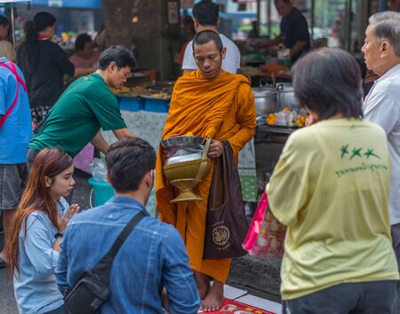 Bangkok, Thailand - January 25, 2015 Unidentified monk is blessing people who giving him foods, lotus and more as offering in morning. This is an usual way of Buddhism.のeditorial素材