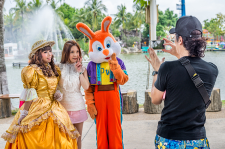 Pathumthani, Thailand - Mar 8 , 2015: Unidentified Asian tourists woman is taking pictuer with two cosplays at Dream World Theme Park.のeditorial素材