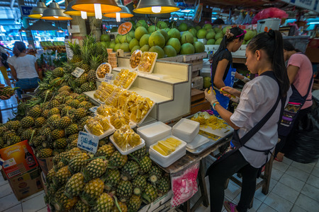 Bangkok Thailand  May 23 2015 Unidentified woman is preparing pineapple for sell at Or Tor Kor markrt a well known place for fresh food fruits and foods. Located next to Jatujak market.のeditorial素材