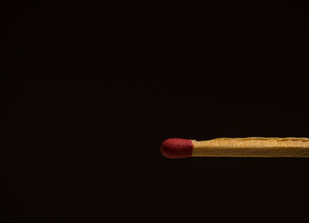 One matchstick in macro shot with black space for writing.