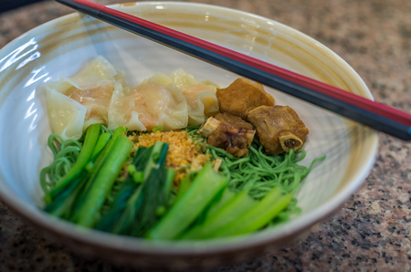 Bowl of dry noodle with Wonton and spare rib.の写真素材