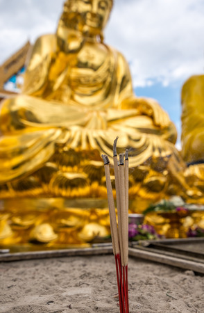 Bangkok, Thailand - Aug 7, 2015 Burning joss stick in front of out door golden Buddha at Wat Trai Mite or Trai Mit Temple.のeditorial素材