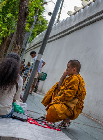 Bangkok, Thailand - Sep 12, 2015 Unidentified monk on the phone in front of sidewalk shop in area of Sanam Luang, the open field and public square near The Grand Palaceのeditorial素材