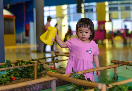 Thai toddler girl with 2 years old is playing gardening in indoor playgroundの写真素材