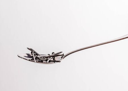 Nails in a spoon . Concept of feeling pain with eatingの写真素材
