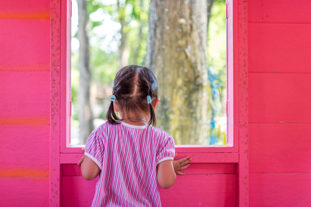 Behide of Asian toddler girl in a colorful kid-play-houseの写真素材
