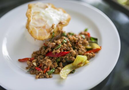 Moo Pad Kra Prow or Mint pork with basil over rice is a classic Thailand traditional food. Perfect with one fried egg.の写真素材