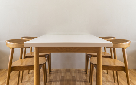 White table in white room and wooden floor. Four wooden chait. Image is shot in low position.の写真素材