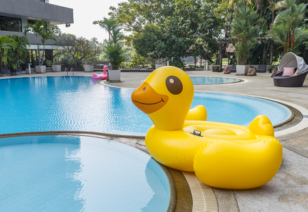 Big inflatable yellow duck at swimming pool without people in a morning.の写真素材