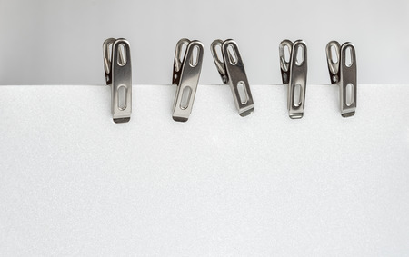 Close up Aluminium binder clip. Low of  Aluminium binder clip. Clip on white blank page.の写真素材