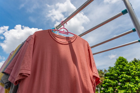 Drying colorful clothes by hanging on bar. Low angle view.の写真素材