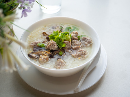 Simple 45 degree angle view Image of rice soup on white table.