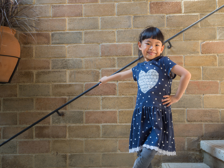 Portrait of small Asian child girl on vacation. Posing and smiling.
