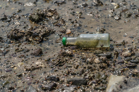 Small glass bottle that people throwaway on a sea shore.
