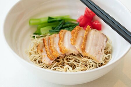 Bowl of noodle with roasted pork on white table.の写真素材