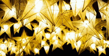 Beautiful yellow lanterns in shape of stars on ceiling.の写真素材
