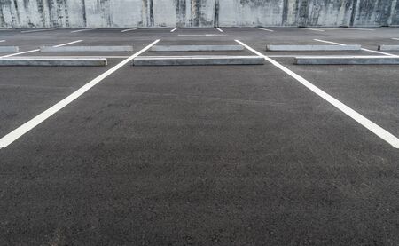 Big space at empty asphalt parking lot with concrete car stopper, perspective and low angle view.の写真素材
