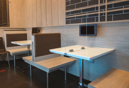 Cleared glass shield to protect virus on small table for two people customer in a restaurant of Thailand, no people in image. Concept for social distancing.の写真素材