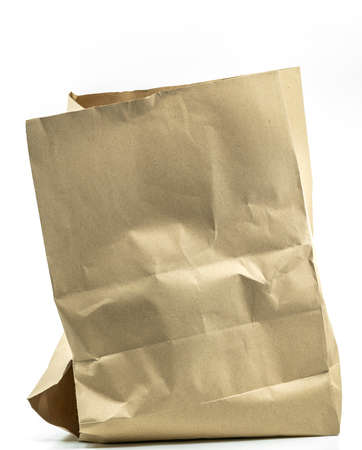 Brown paper bag with large hole at the bottom of the bag, brown paper bag with damage hole on white background. Empty space on front of bag with wrinkles.の写真素材