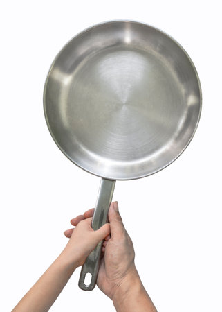 Stainless steel pan fry or skillet with child's hands hold the handle, adult's hand support under child's hand. Top view image, isolated image Stainless steel skillet on white background.の写真素材
