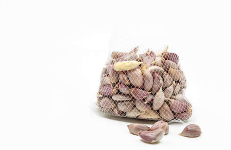 Organic fresh Thai garlics, small garlics in white net bag, some is outside. Close up image net bag...
