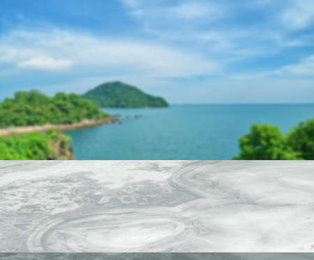 Isolated white marble table or floor, little shiny surface, perspective view, blurred landscape or seascape background, soft blue tone, empty space for product presentation.の写真素材
