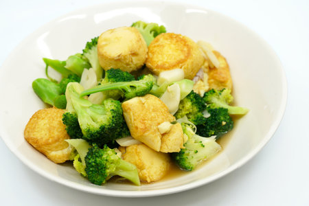 Thai food, Stir-fried broccoli and deep-fried Egg-Tofu with oyster sauce. Healthy food image on white background, view side and above a 45-degree angle.の写真素材