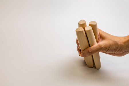 Preparing to throw the Yut sticks of Yut Nori, a traditional Korean game. Hands together. Close-up. Side view.の写真素材