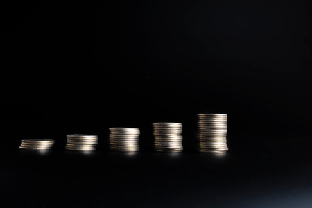 Front view of coins arranged side by side in different heights, symbolizing comparison, growth,...
