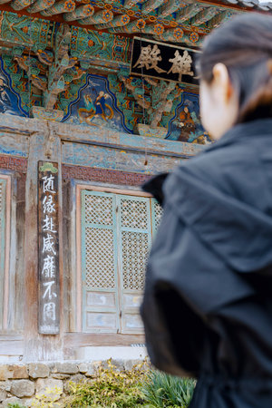A woman praying in front of the Daeungjeon Hall at Jangansa Temple in Gijang, Busan, South Korea.の写真素材