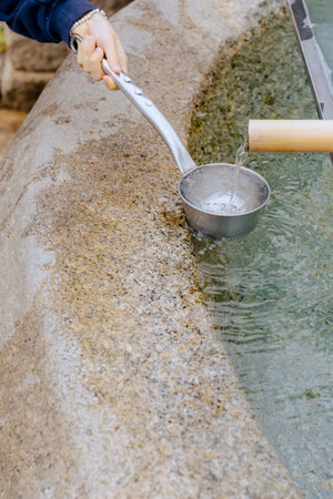 Close-up of a child's hand receiving clean, cool, flowing water from a ladle.の写真素材