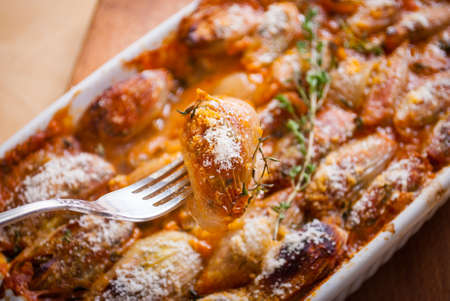 Baked onions stuffed with feta cheese and tomatoes with herbsの写真素材