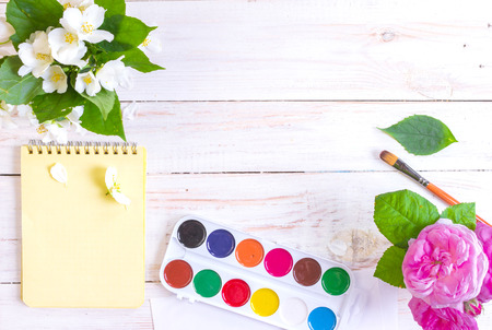 Desk of creative worker. Paints, brush and flowers. Top view backgroundの写真素材