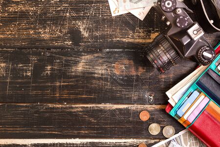 Camera, touristic maps, headphones, wallet with credit cards, euro banknotes and coins on the black...