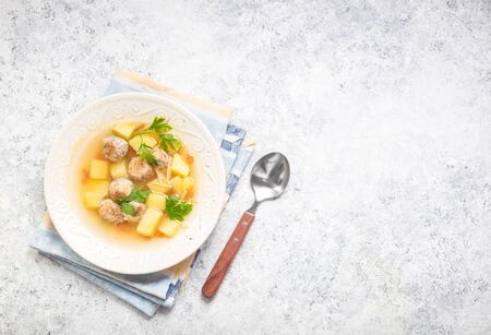 Homemade soup in bowl, chicken meatballs. White concrete rustic background. Space for text. Healthy warm meatballs soup for dinner. Meatballs soup concept. Preparing soup for dinner or lunch. Top viewの写真素材