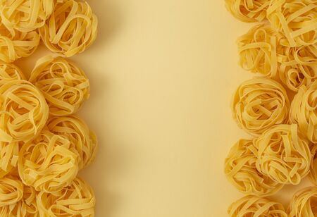 Minimal food pattern of pasta tagliatelle, light yellow pastel background with space for text....