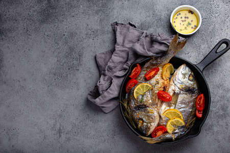 Grilled fish sea bream or dorado in cast iron skillet copy space