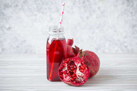 Pomegranate juice in bottle and fruitの写真素材