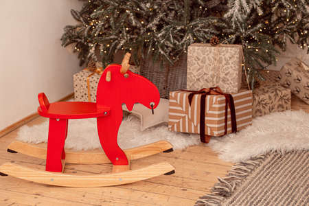 Rocking red horse under festive Christmas tree with giftsの写真素材